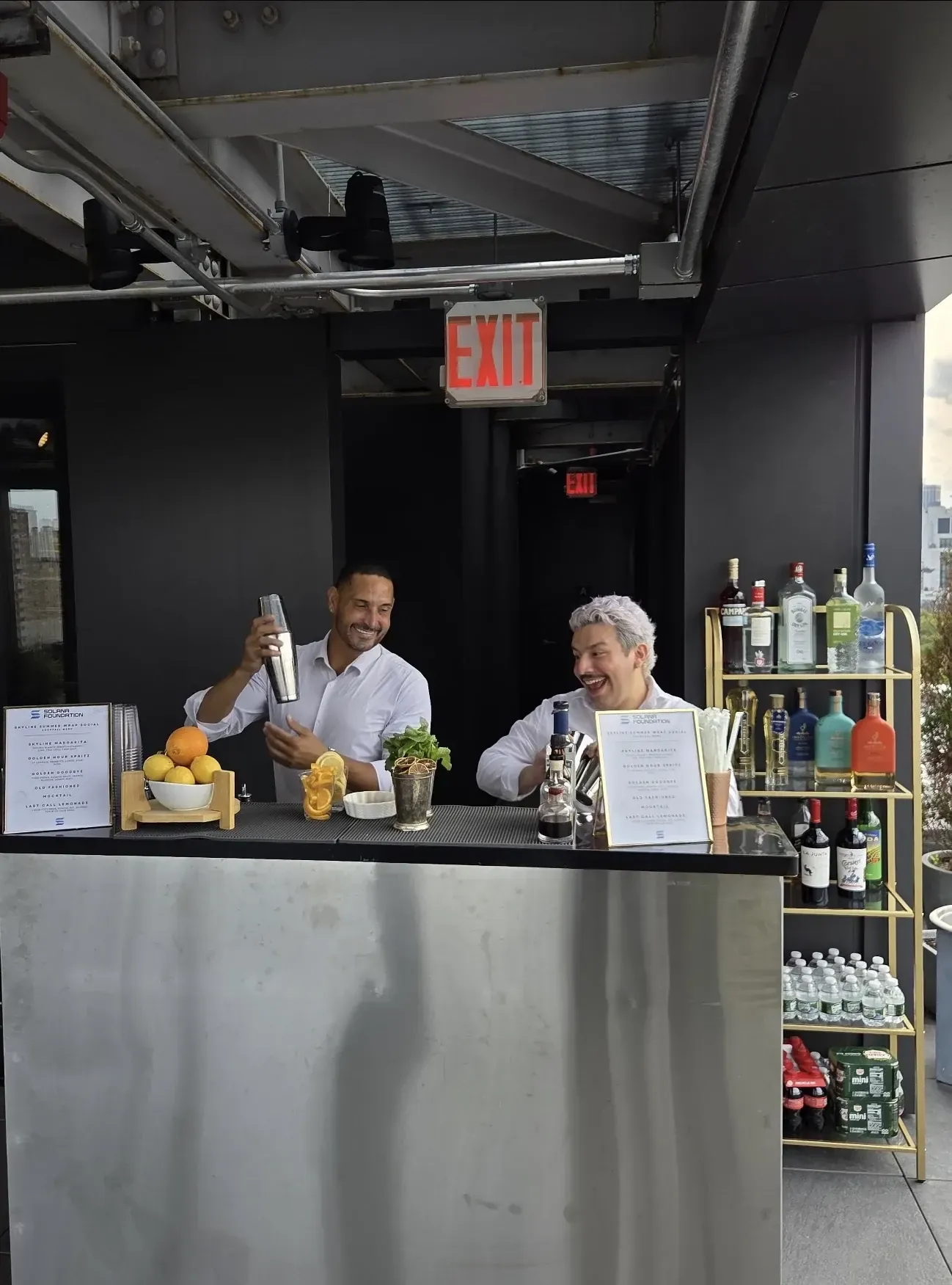 WOA bartenders running a mobile bar on a rooftop with the New York skyline behind them